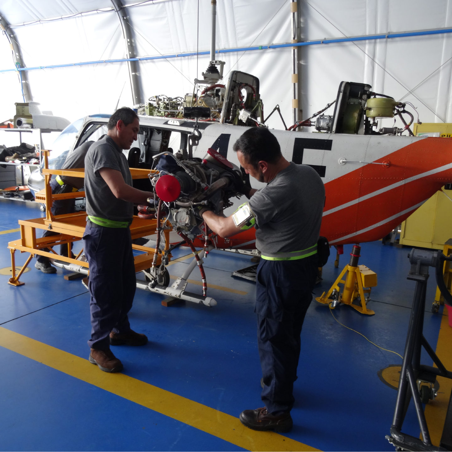 men performing helicopter maintenance